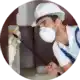man spraying insectide chemical wearing safety equipment
