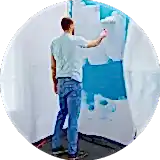 a man standing inside the house and painting the wall with a roller painting brush