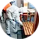 a man in ppe kit and chemical jar on back spraying pesticide on furniture