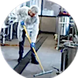 man cleaning floor of an industry with big boilers