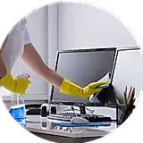 applying cleaner and wiping a desktop screen at a work desk