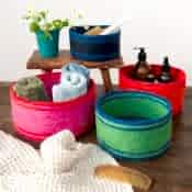 Four woven storage baskets in varying sizes and colours