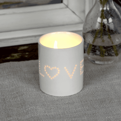 White ceramic tea light holder with the word 'LOVE' cut out, where the letter 'O' is replaced by a heart shape.