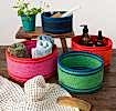 Four woven storage baskets in varying sizes and colours