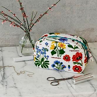 White oilcloth makeup bag with images of wild flowers