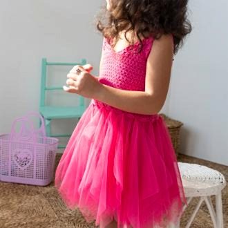 A child dressed in a bright pink crochet, suggesting a costume or dress-up occasion.