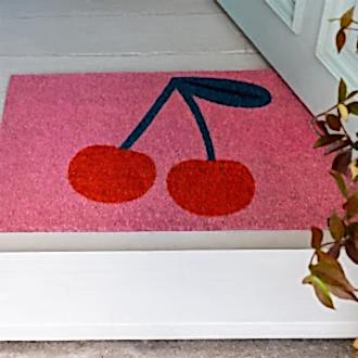 doormat featuring red cherry print in a pink background
