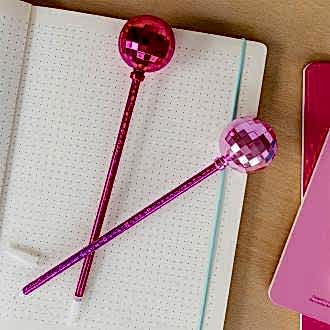two dsico ball pens in pink placed on a notebook