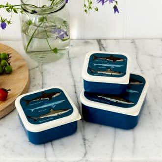 Three plastic snack boxes in dark blue and cream featuring pictures of sharks