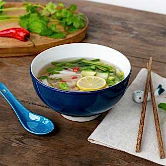 Blue ceramic noodle bowl set with spoon, chopsticks, and fish-shaped rest