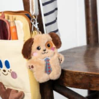dog-shaped plush keyring wearing a tie with brown ears 