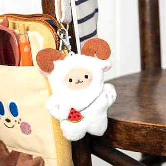 Yeti-shaped plush keyring with pink ears and paws, a watermelon accessory with metal clasp