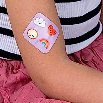 Plaster applied to a kid's arm with a kawaii sunshine-themed design.