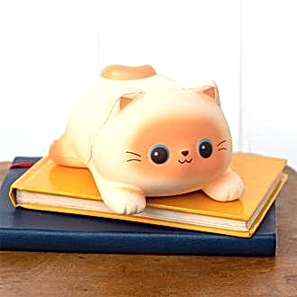 Squidgy stress cat lying on a book.