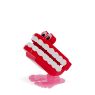 Wind-up toy shaped like red chattering teeth with white teeth, googly eyes, and pink feet