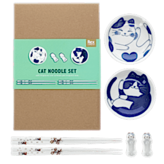 Two cat-themed dipping bowls, two pairs of chopsticks, and two cat-shaped rests beside a brown box.