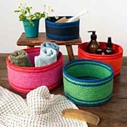Four woven storage baskets in varying sizes and colours