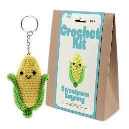 Crochet kit packaging displayed next to a finished yellow and green leaf sweetcorn keychain
