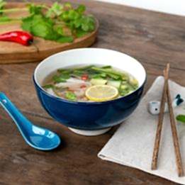 Blue ceramic noodle bowl set with spoon, chopsticks, and fish-shaped rest
