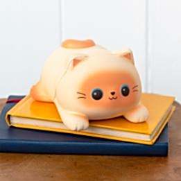 Squidgy stress cat lying on a book.