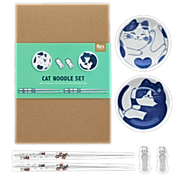 Two cat-themed dipping bowls, two pairs of chopsticks, and two cat-shaped rests beside a brown box.
