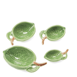 Set of four ceramic measuring spoons shaped like green leaves with brown stem handles 