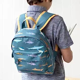 Mini backpack for kids with pictures of sharks worn by child