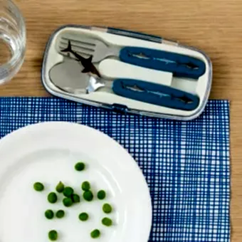Stainless steel fork and spoon with dark blue plastic handles featuring with pictures of sharks in plastic carry case on table