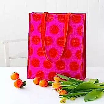 Recycled plastic shopping bag red circles pink background