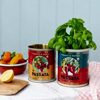 Passata metal storage tins, one containing a plant