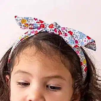 A child wearing a colourful floral fabric headband - Tilde