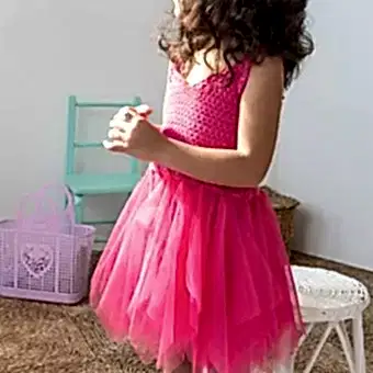 A child dressed in a bright pink crochet, suggesting a costume or dress-up occasion.