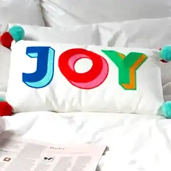 Embroidered cushion with pom poms - Joy