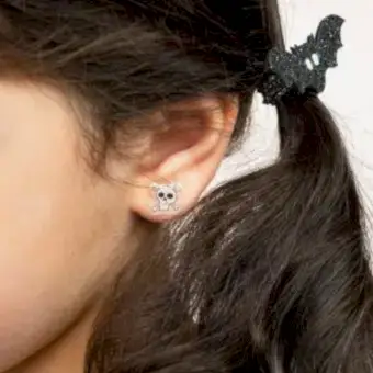 girl wearing small white skull-shaped earring