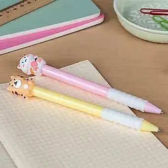 Pink and yellow retractable ballpoint pen with cat and tiger sitting atop