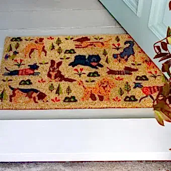 Colourful doormat featuring various dogs in different poses and colours