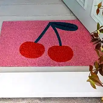 doormat featuring red cherry print in a pink background