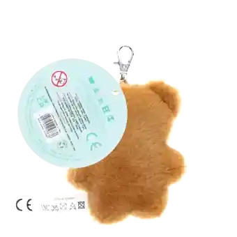 Light brown plush teddy bear keychain with a red polka-dotted bandana, metal clasp for attachment, and a tag with safety warnings
