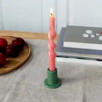 Khaki ceramic candle holder with a cylindrical shape and wide flat base, holding a lit pink candle