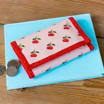 Wallet in pink featuring colourful illustrations of red cherry print