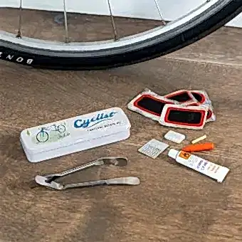 cyclist puncture puncture repair kit beside a storage tin