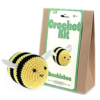 Crochet kit packaging and finished crocheted bee beside it