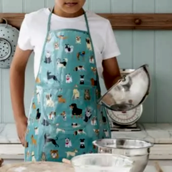 Colourful aprons designed for children, each featuring playful dog illustrations.
