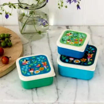 Three plastic snack boxes in blues greens and cream featuring prints of fairies amongst flowers