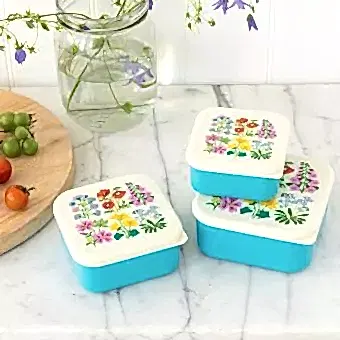 Three plastic snack boxes in turquoise and cream featuring floral pattern