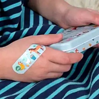 Plaster applied to a kids' hand with a farmyard-themed design.