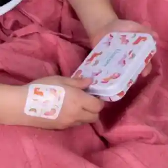Plaster applied to a kid's hand with a unicorn-themed design.