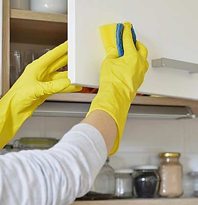 man scrubbing kitchen cabinets