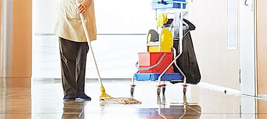 man mopping the floor with cleaning equipments